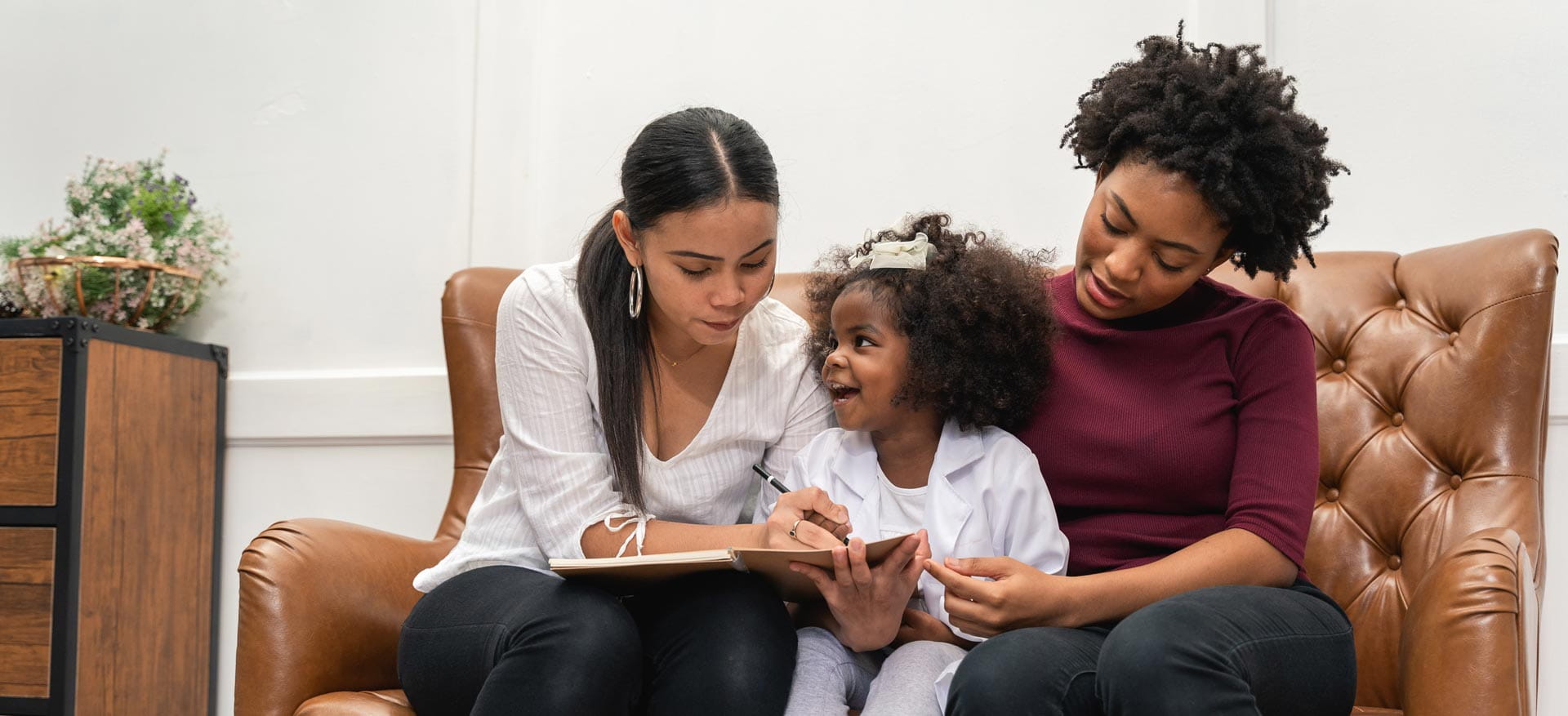 A young girl reading with her mums