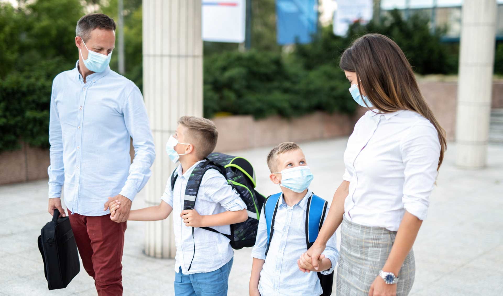 A family walking together, all wearing masks